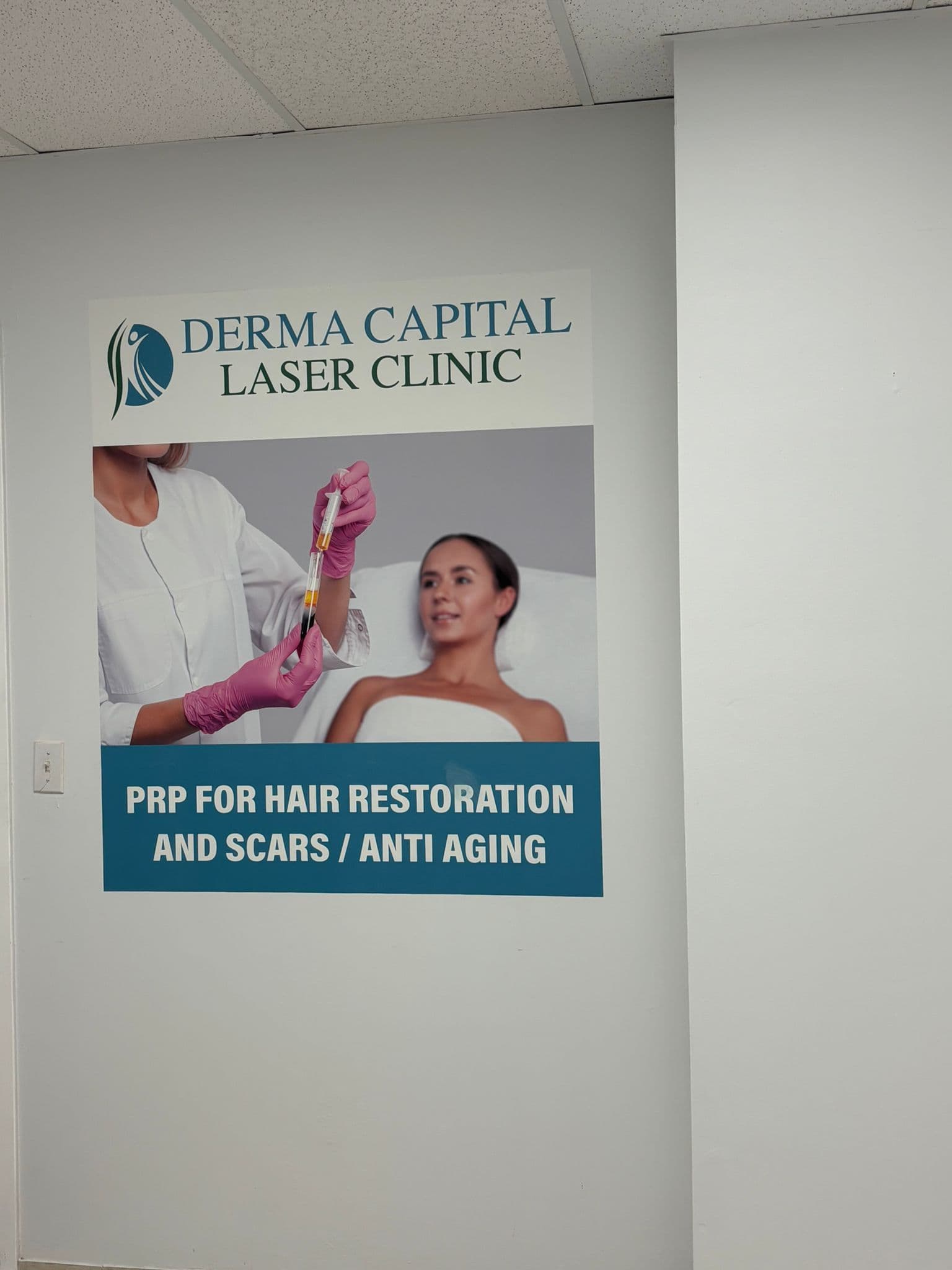 A clinic practitioner and front desk team member reviewing patient feedback together on a tablet at the reception area of a dermatology laser clinic
