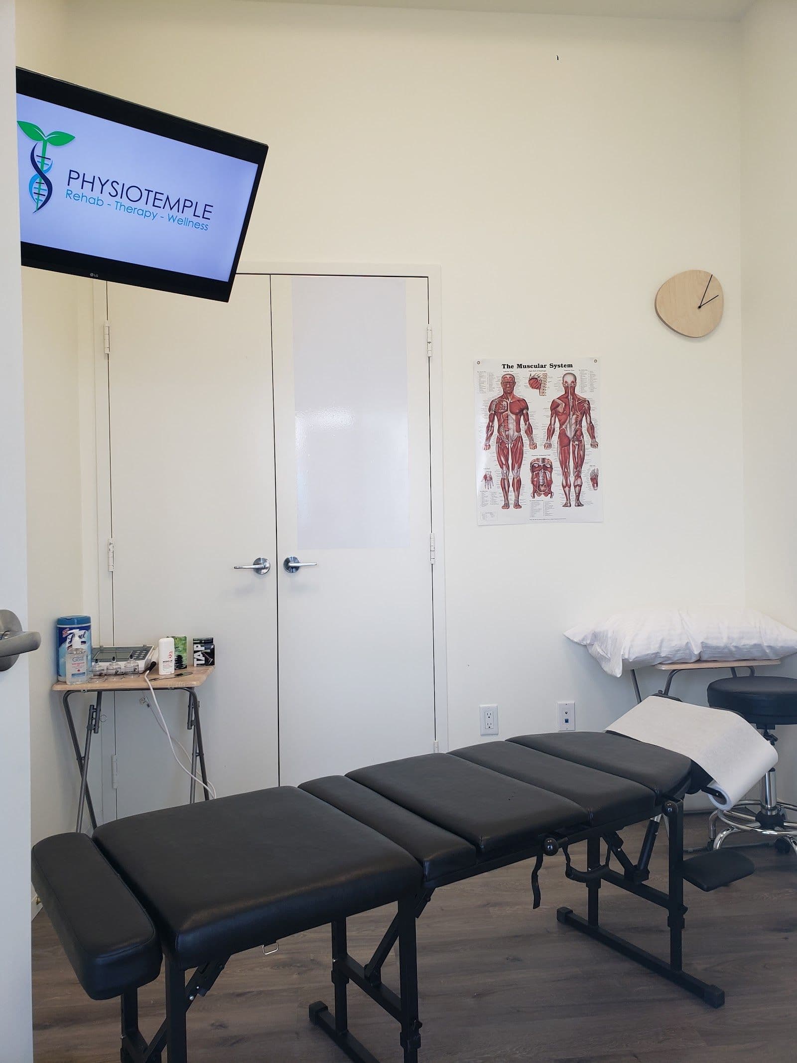Physiotemple clinic team reviewing patient feedback together at the front desk, with treatment rooms visible in the background