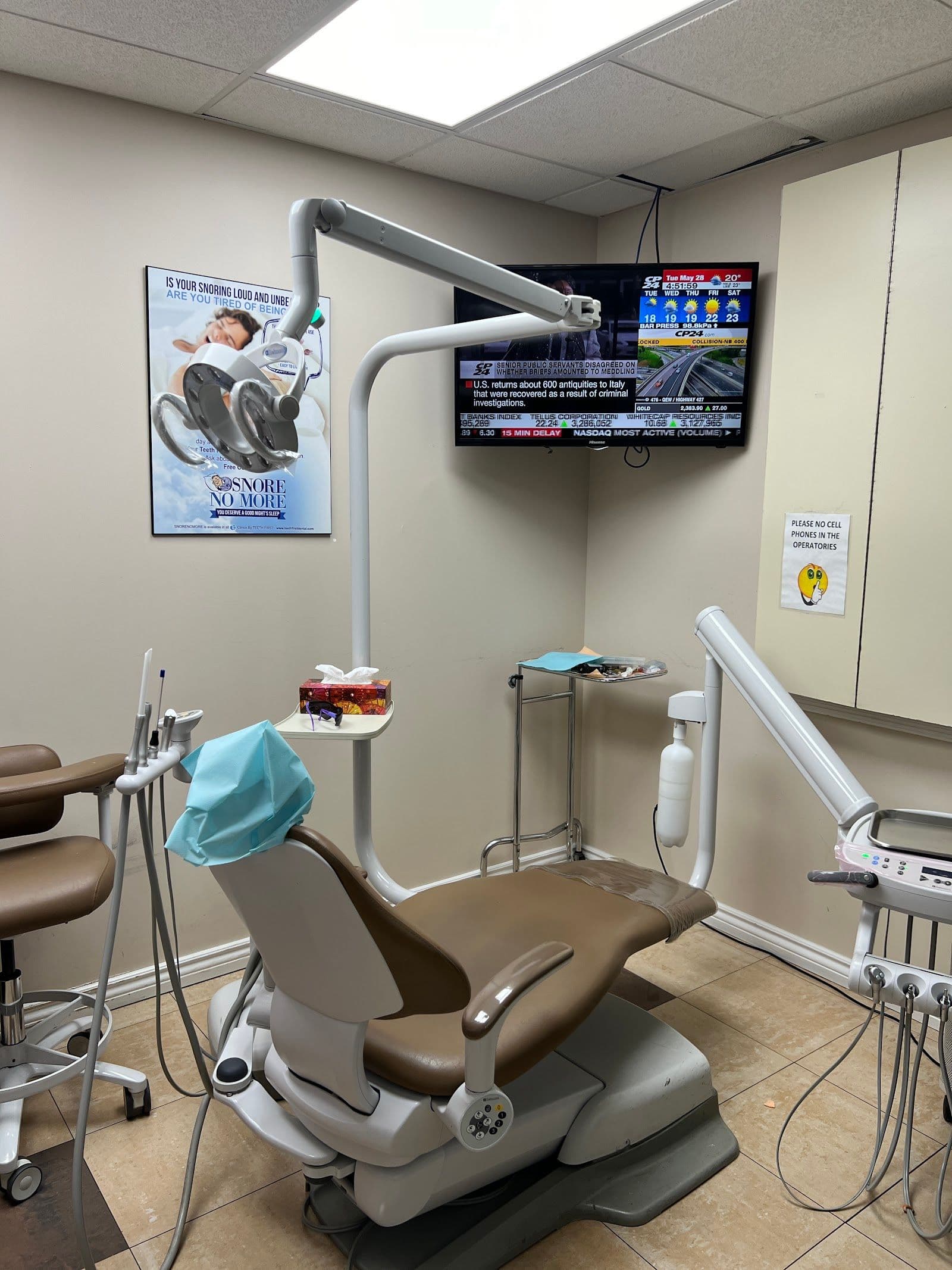A dental clinic front desk team reviewing patient feedback together on a tablet, with a bright and welcoming reception area in the background