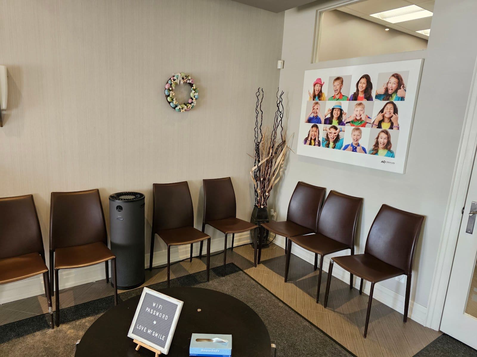 Orthodontic clinic front desk team reviewing patient feedback together on a tablet in the reception area