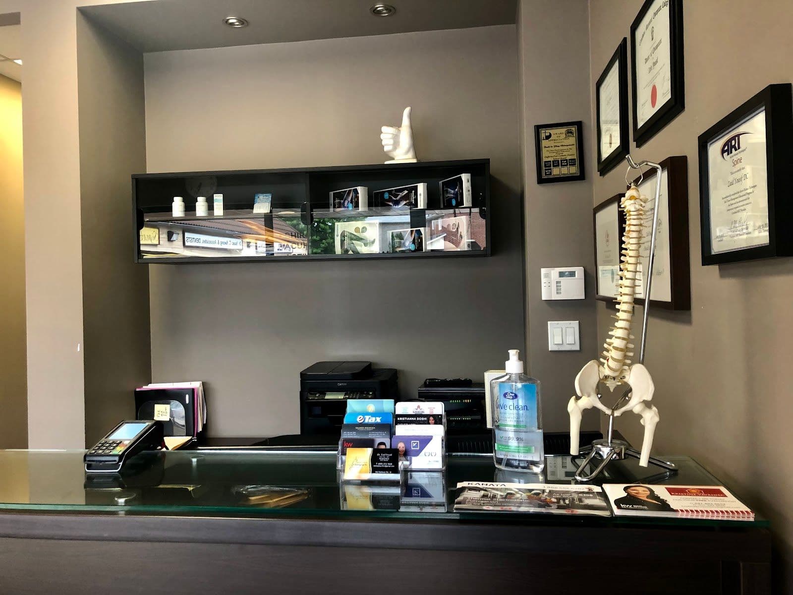 Chiropractic clinic team reviewing patient feedback together at the front desk, with a tablet showing Google review summaries