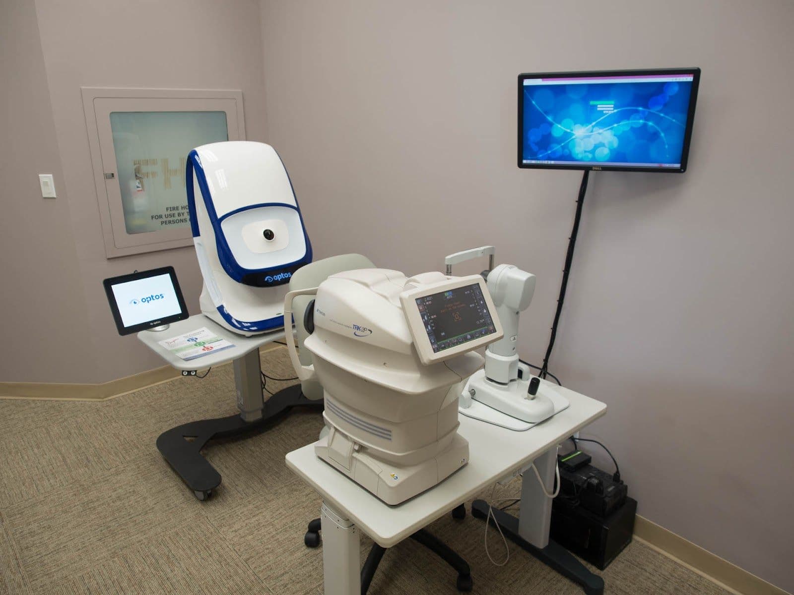 Optometry clinic front desk team reviewing patient feedback together on a tablet at the reception counter