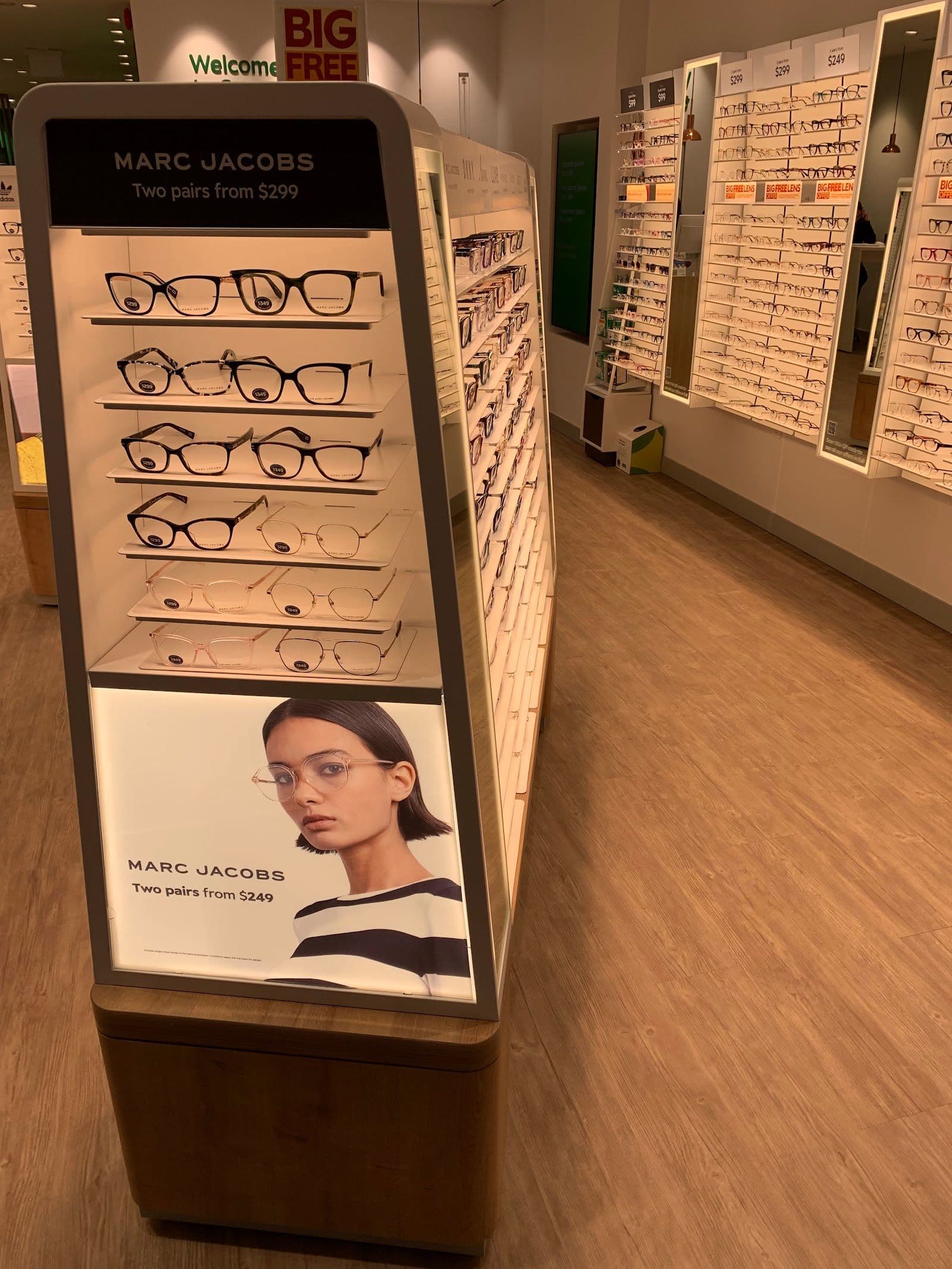 Optometry clinic team reviewing patient feedback and Google reviews together at the front desk of an eye care practice
