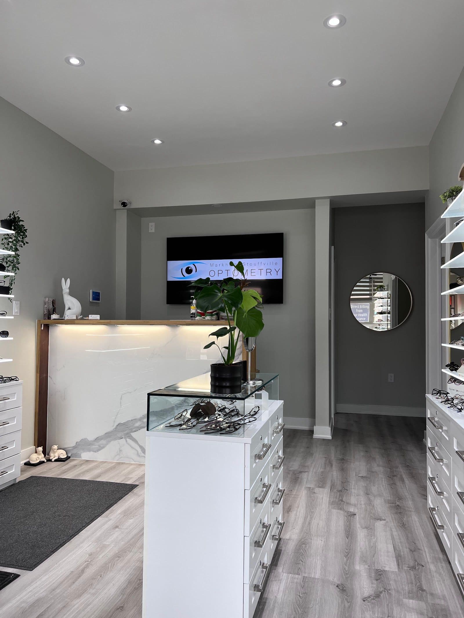 Optometry clinic team reviewing patient feedback and Google reviews together at the front desk of a bright, modern optometry office