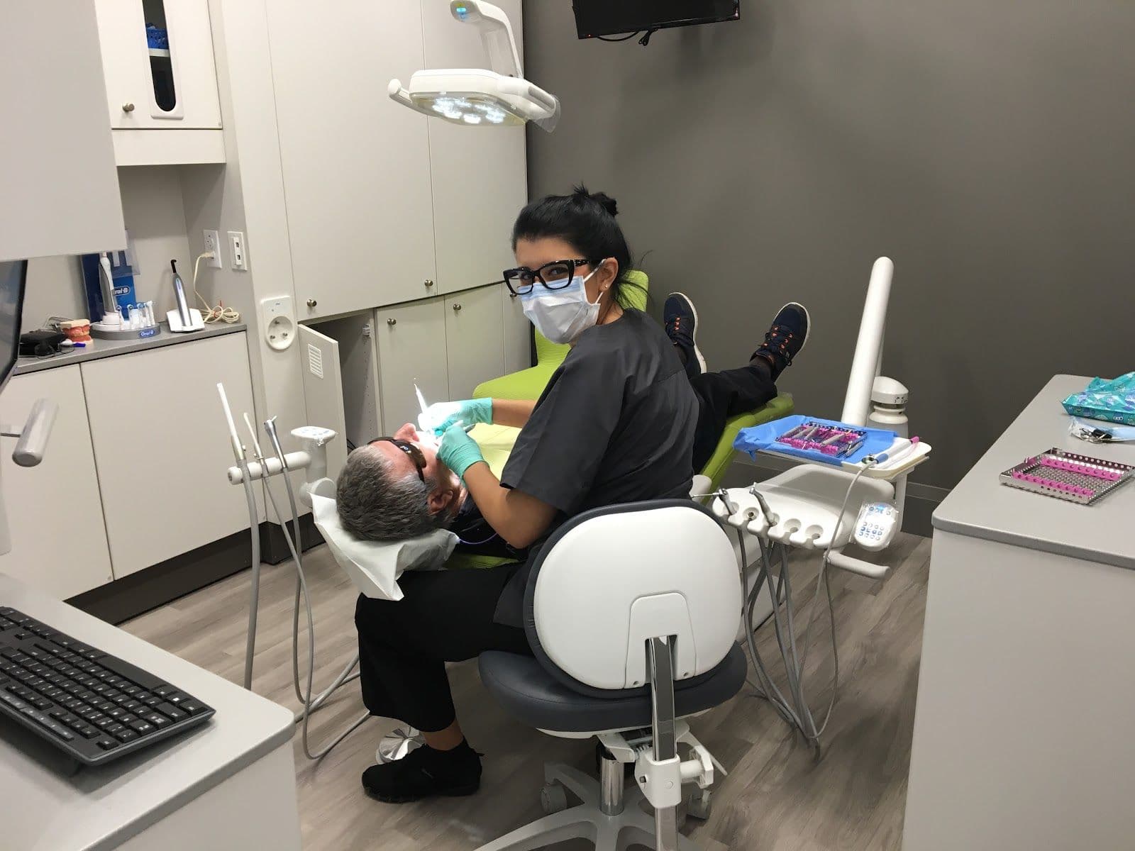 Dental clinic front desk team reviewing patient feedback together on a tablet at the reception area of Mackenzie Dental Centre
