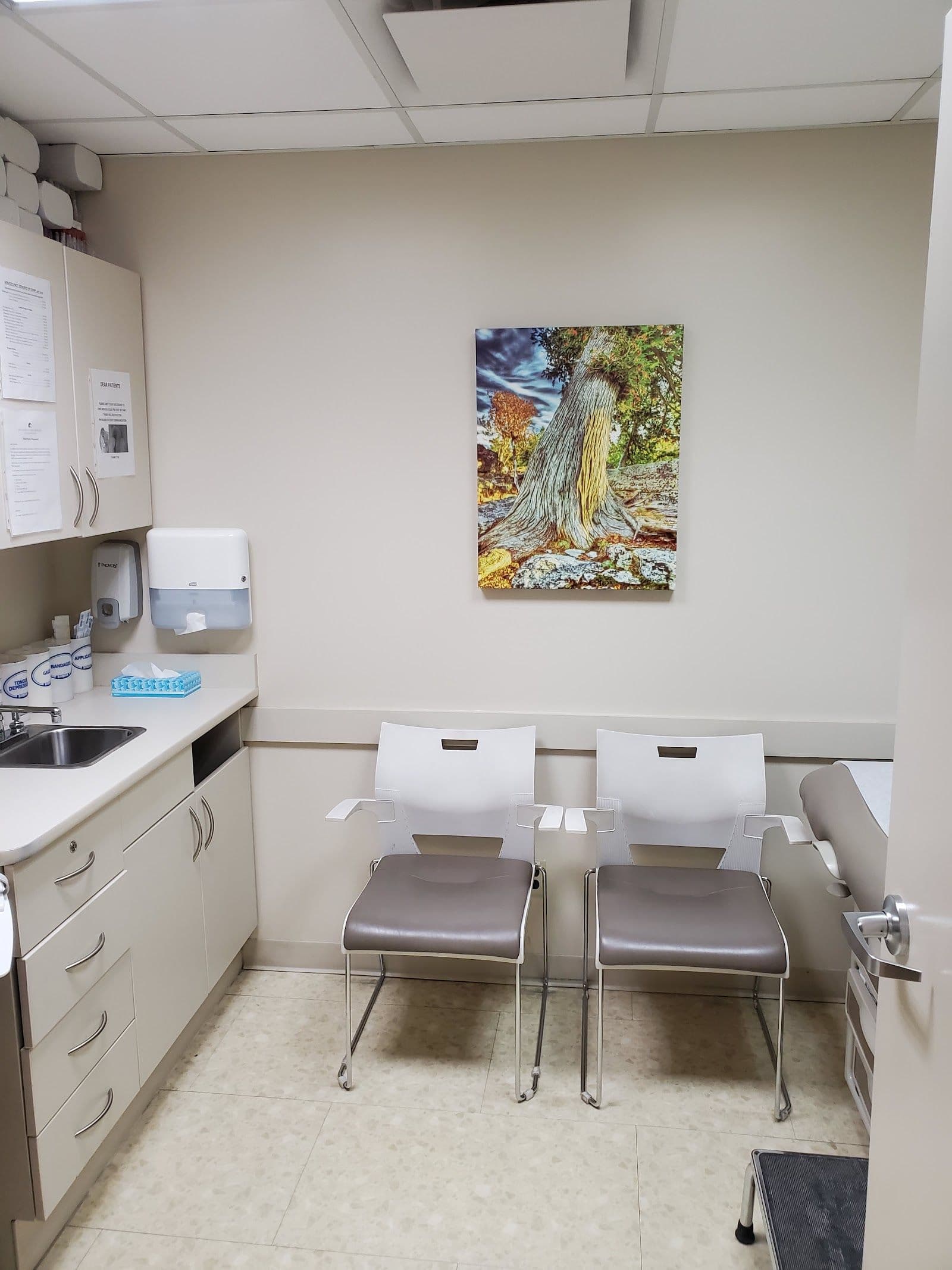A clinic team member and practice manager reviewing patient feedback together at the front desk of a family medicine clinic