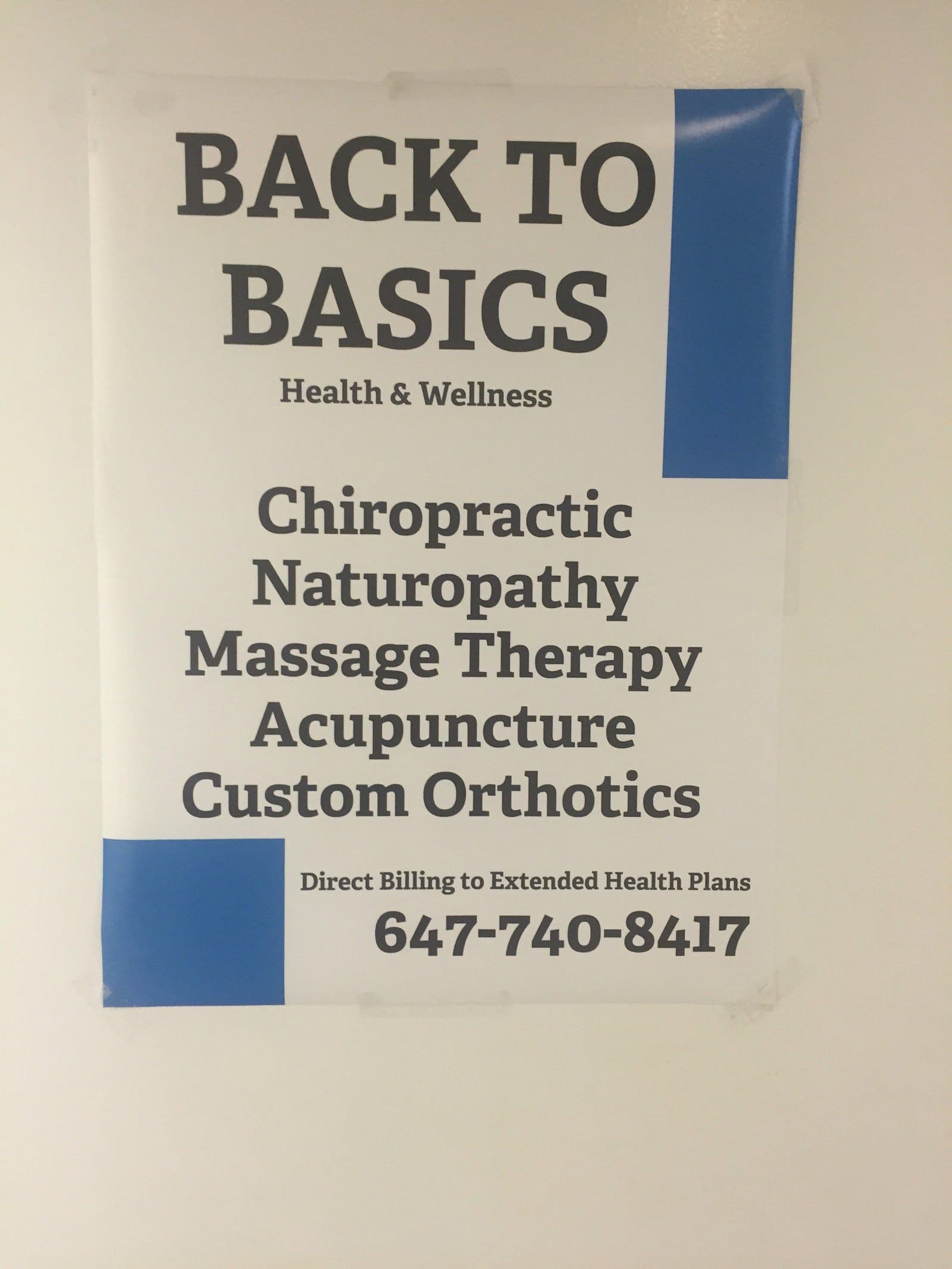 A clinic team member reviewing patient feedback on a tablet at the front desk of a chiropractic and wellness clinic
