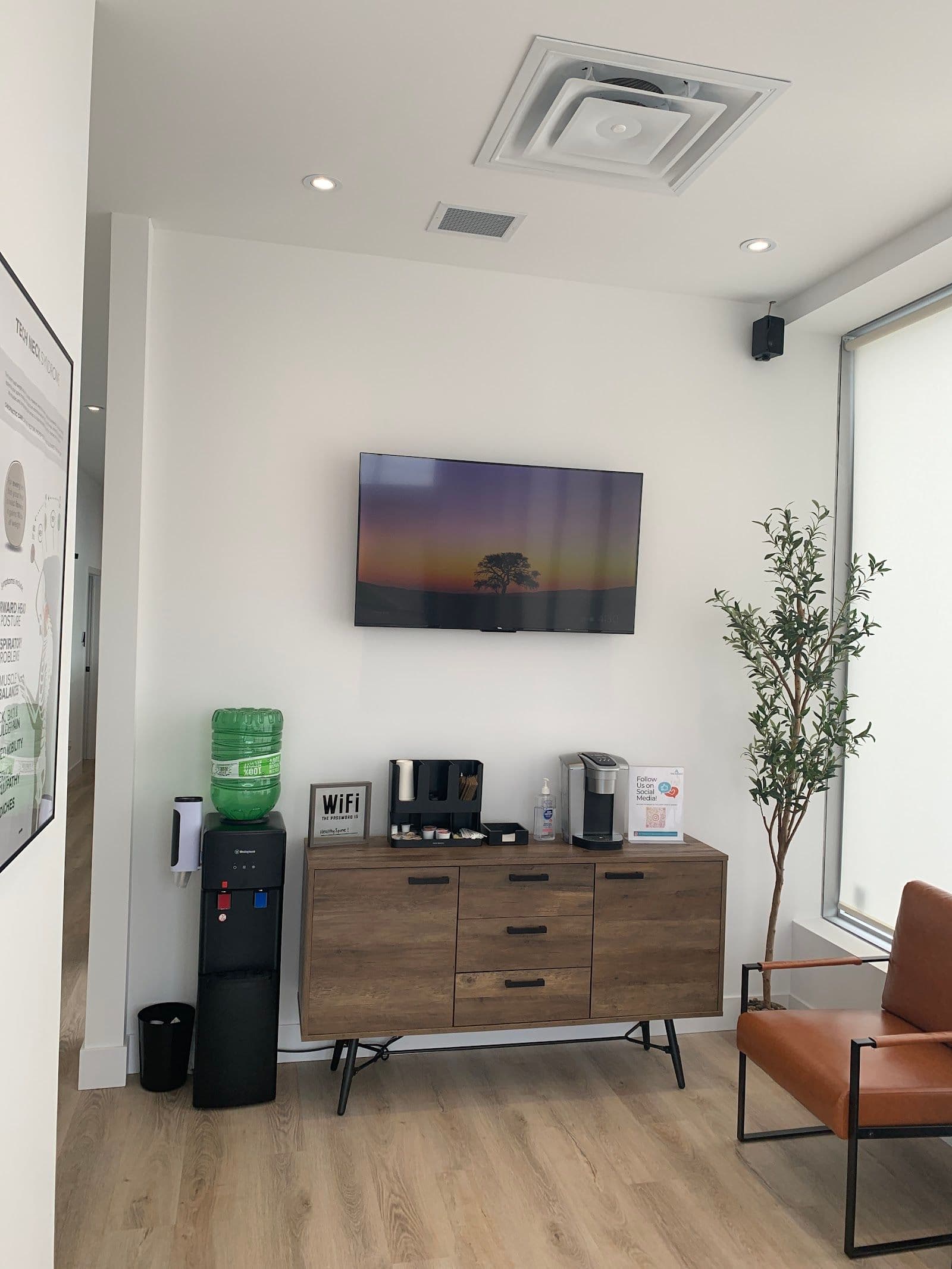 Chiropractic clinic front desk team reviewing patient feedback together on a tablet in the reception area