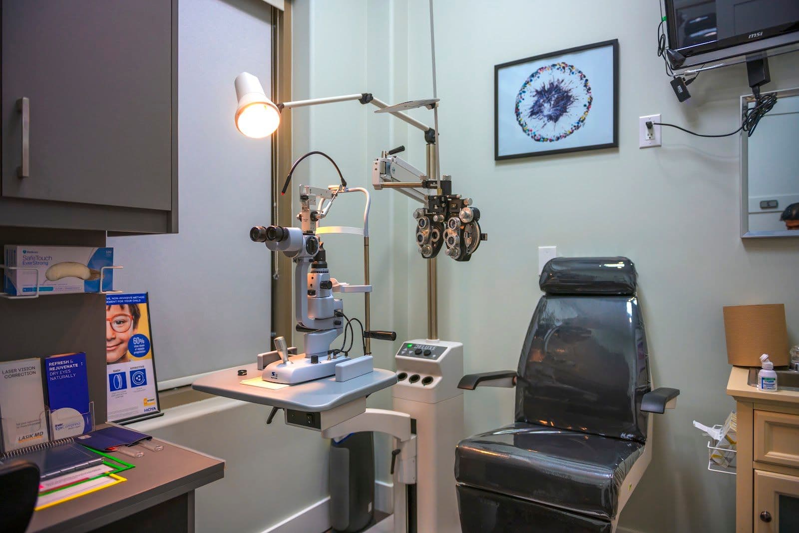 An optometry clinic team reviewing patient feedback and Google reviews together at the front desk