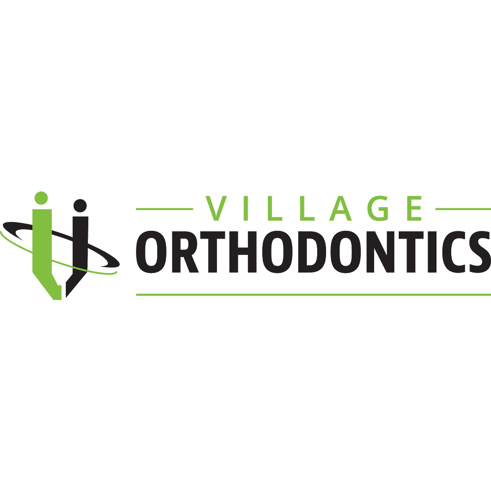 Orthodontic clinic front desk team reviewing patient feedback and Google reviews together on a tablet in a bright treatment area