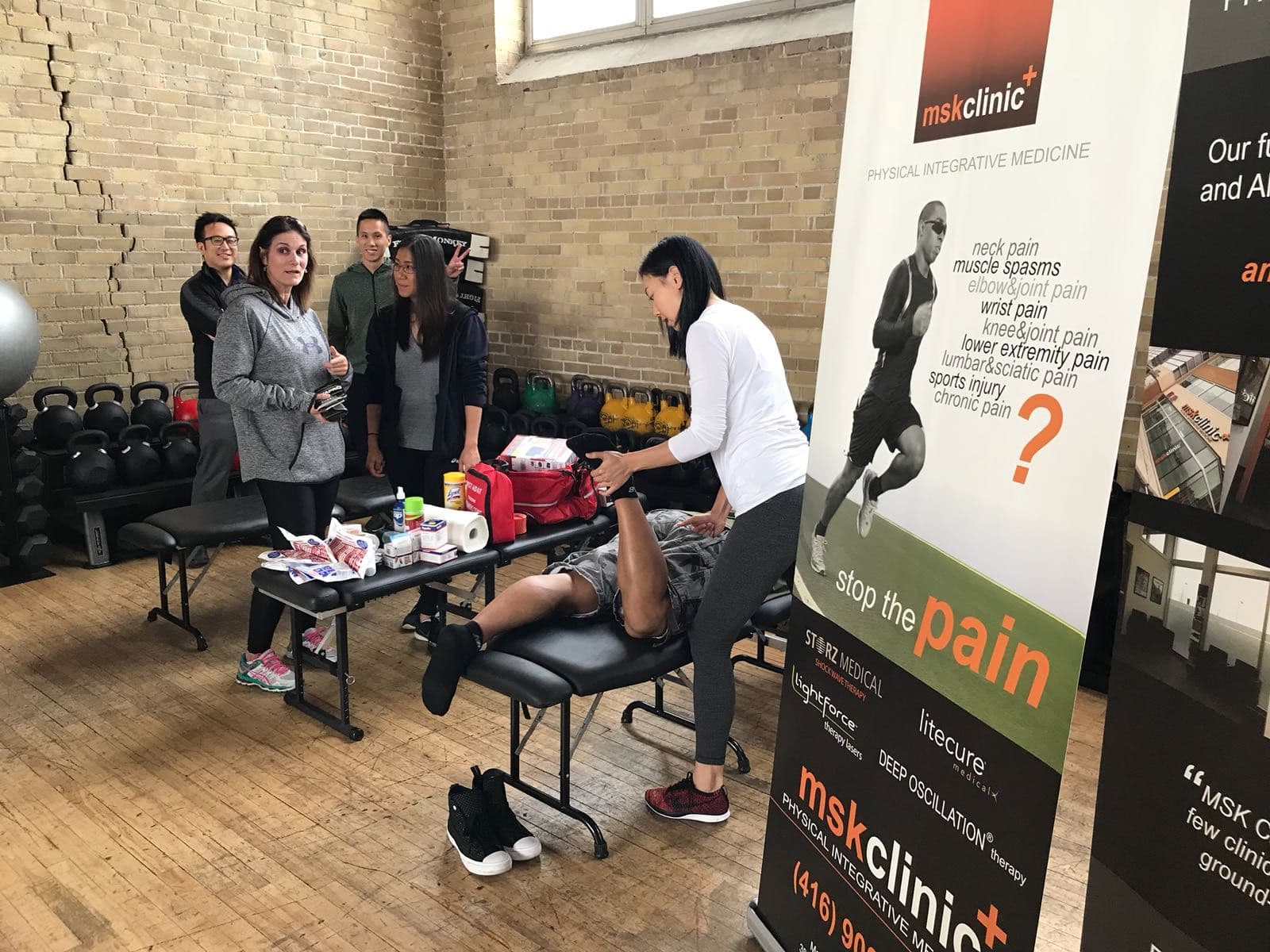 Chiropractic clinic front desk team reviewing patient feedback together on a tablet in a bright, welcoming reception area