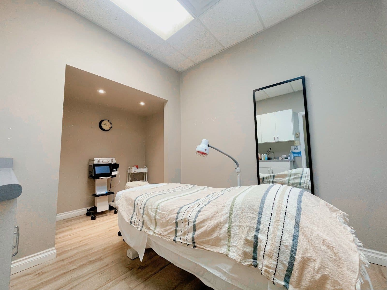 A wellness clinic team member reviewing patient feedback on a tablet at the front desk of a calm, professional treatment clinic