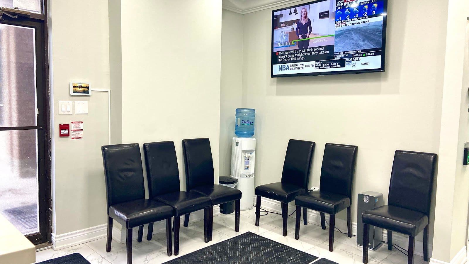 A dental clinic front desk team reviewing patient feedback together on a tablet, with a clean and modern reception area in the background