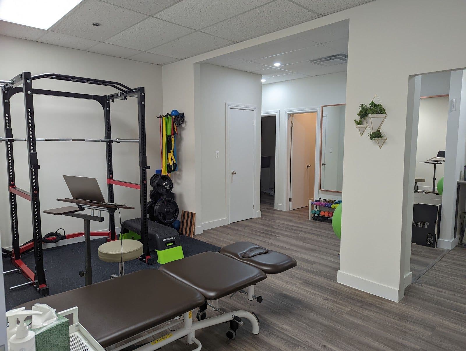 A physiotherapy clinic front desk team reviewing patient feedback and Google reviews together on a tablet in a bright, organized reception area