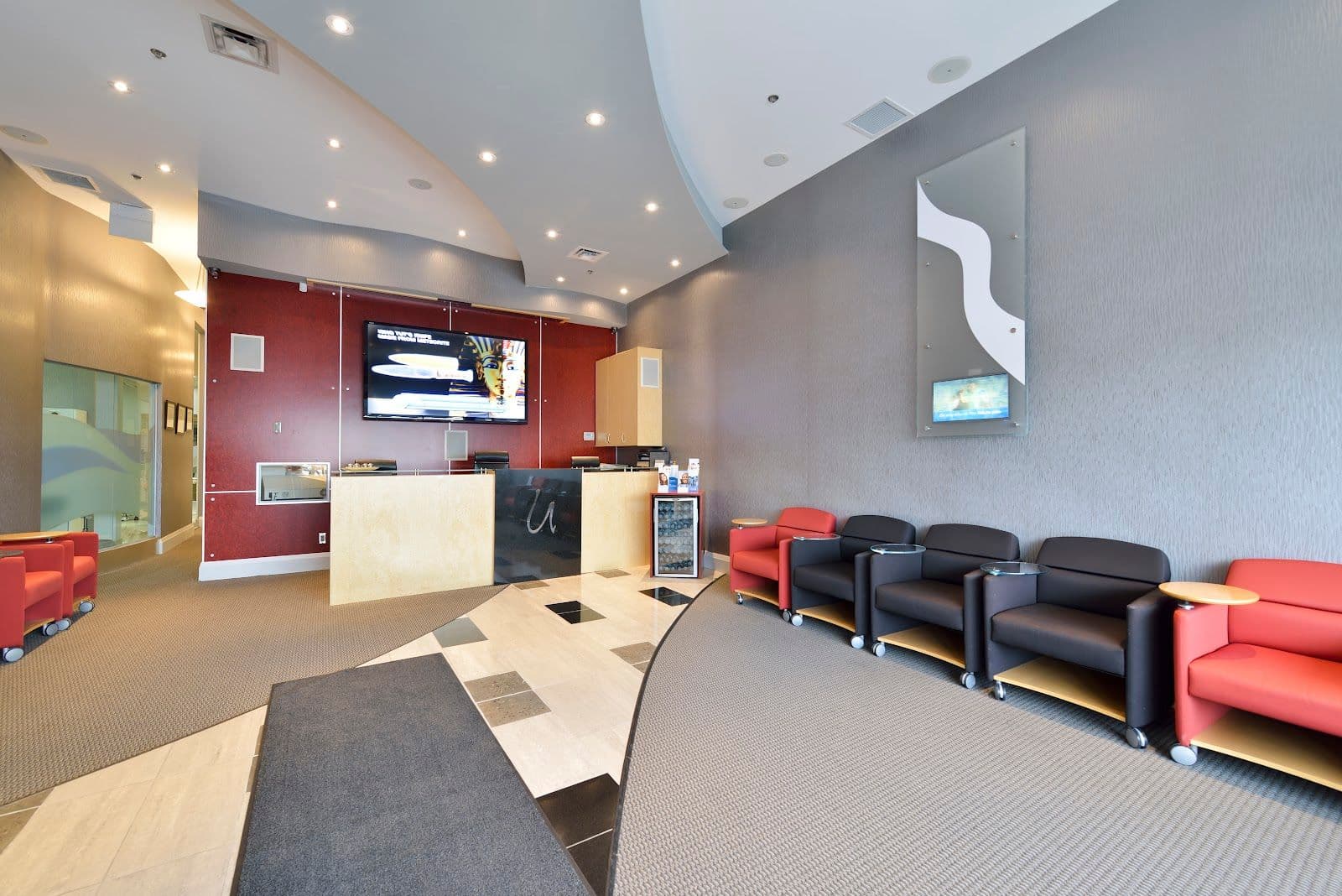 A dental clinic front desk team reviewing patient feedback together on a tablet in a bright, modern reception area