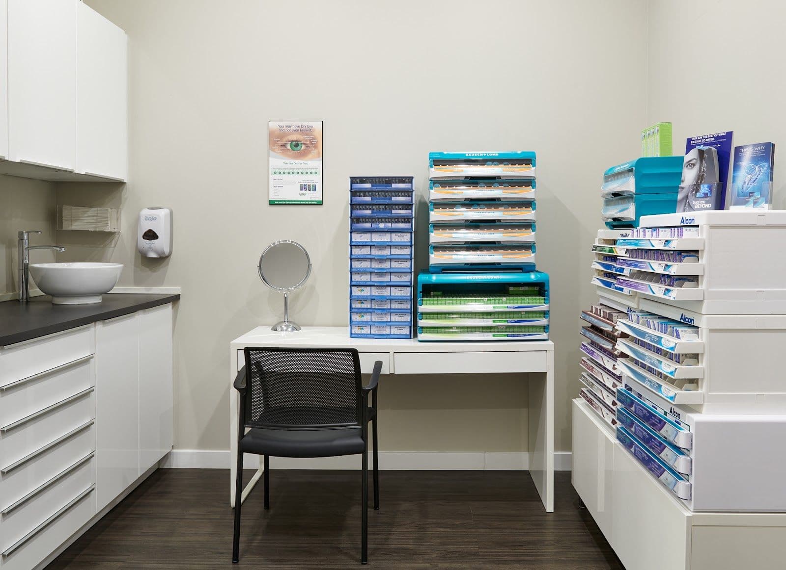Optometry clinic team member reviewing patient feedback on a tablet at the front desk of a modern eye care practice
