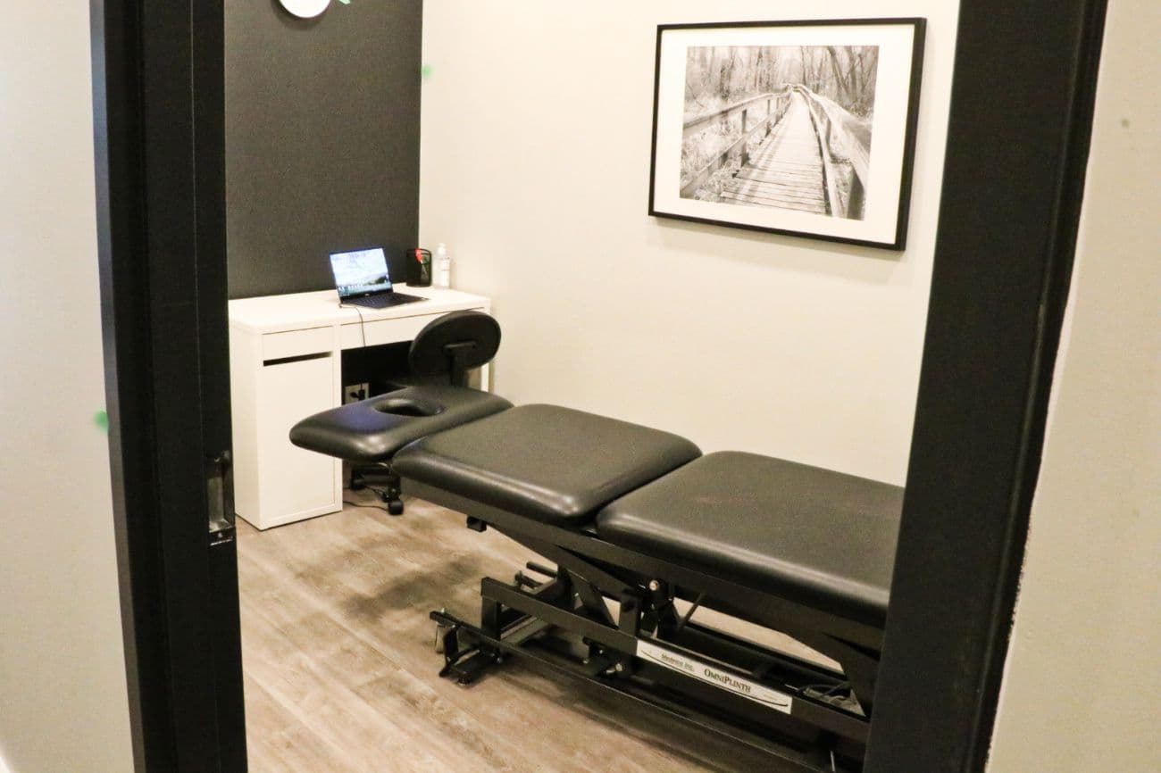 Physiotherapy clinic team reviewing patient feedback and Google reviews together at the front desk of a bright, welcoming clinic