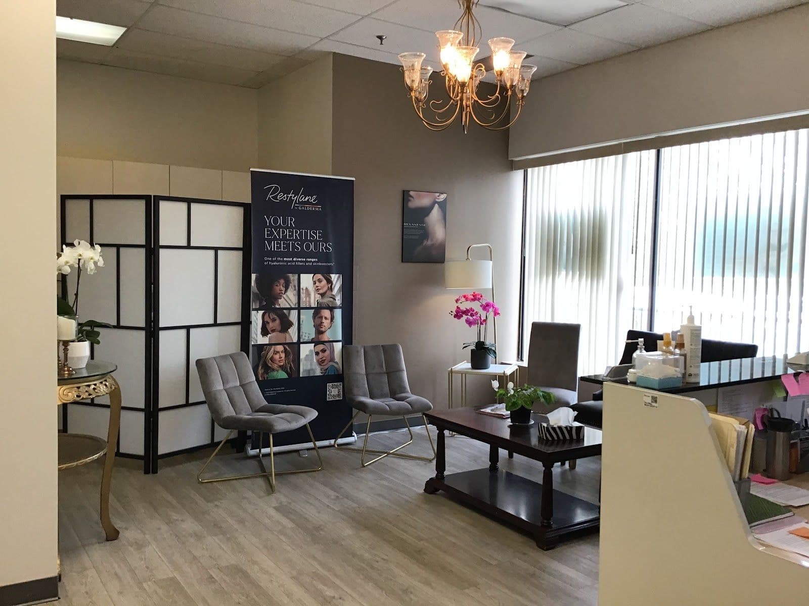 A clinic team member and practice manager reviewing patient feedback together at the front desk of a dermatology and aesthetics clinic