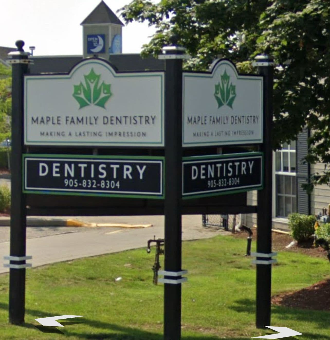 Dental clinic front desk team reviewing patient feedback together on a tablet in the reception area of Maple Family Dentistry