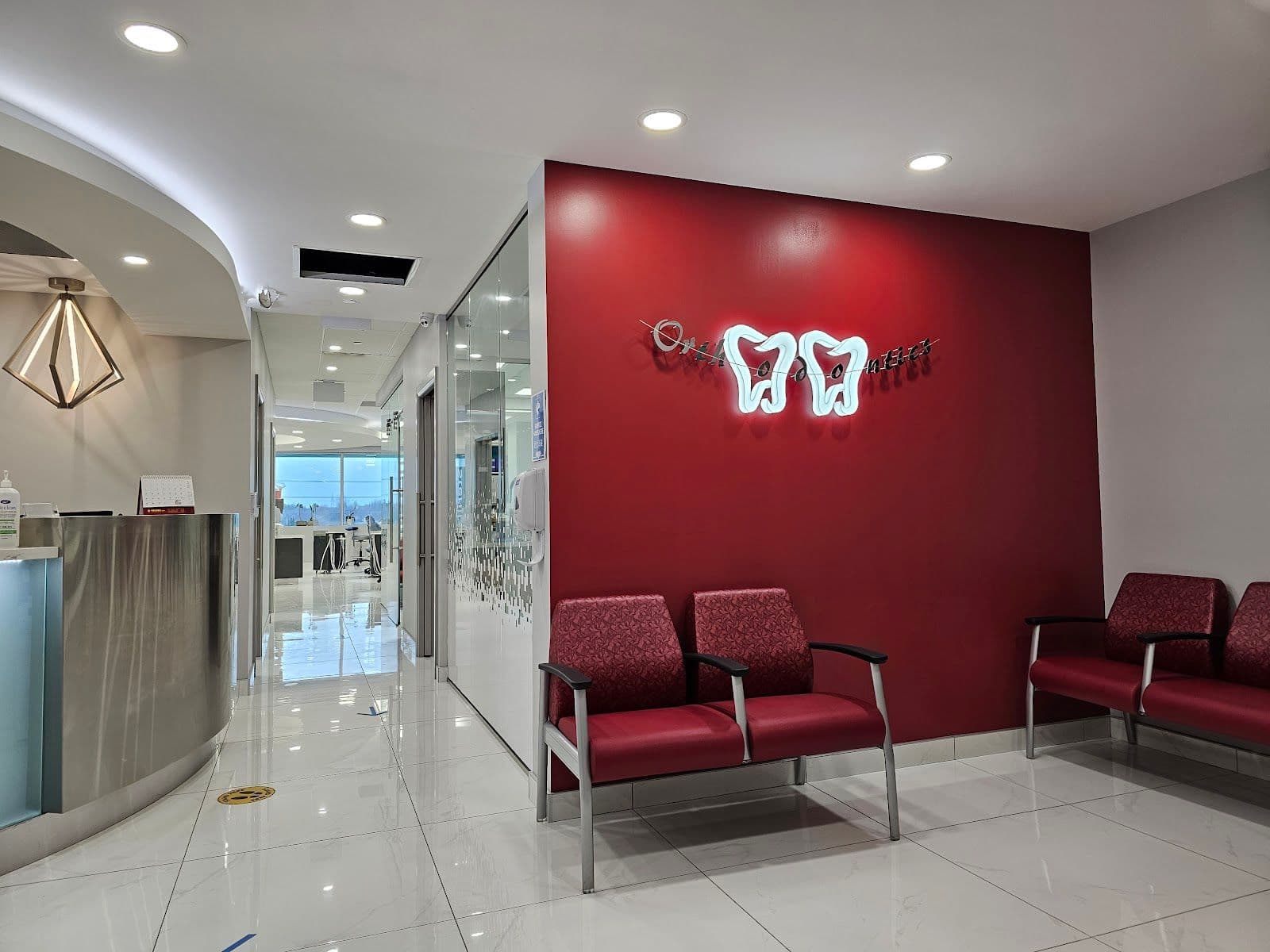 Orthodontic clinic front desk team reviewing patient feedback together on a tablet in a bright, clean reception area