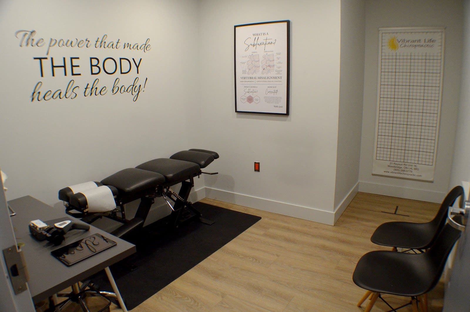Chiropractic clinic front desk team reviewing patient feedback together on a tablet in a bright, modern treatment area